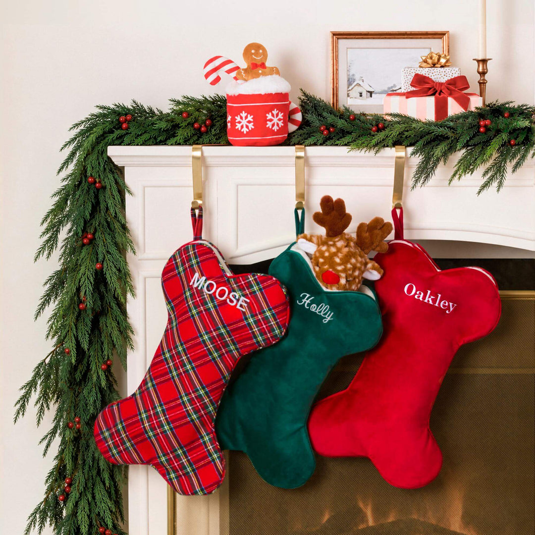 Mantel with garland and tartan, green, and cranberry dog stockings from the same bone stocking line