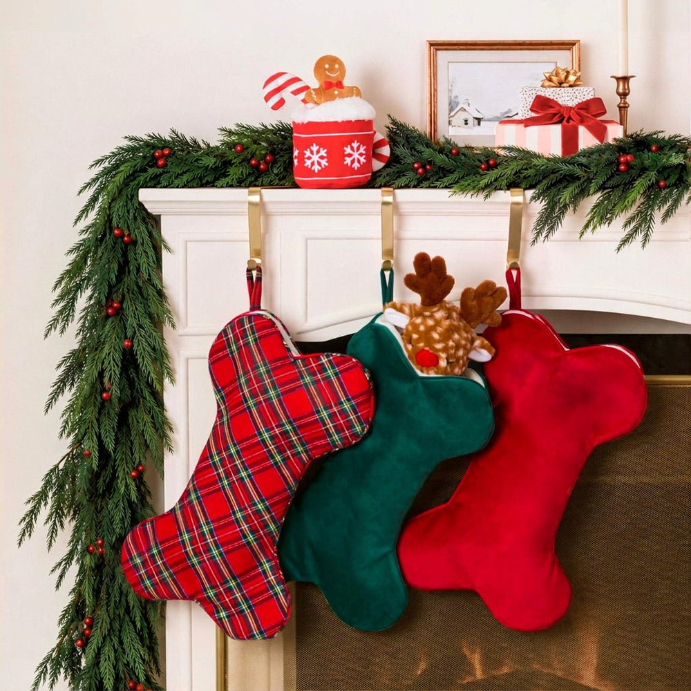 Garland mantel hung with tartan, green velvet, and cranberry velvet dog stockings