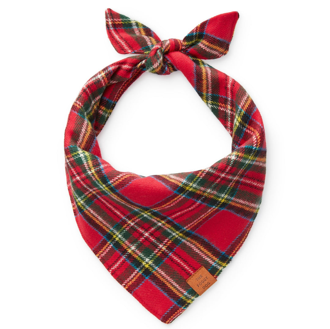 Red tartan plaid flannel dog bandana tied in a loop on white, leather tag at the corner