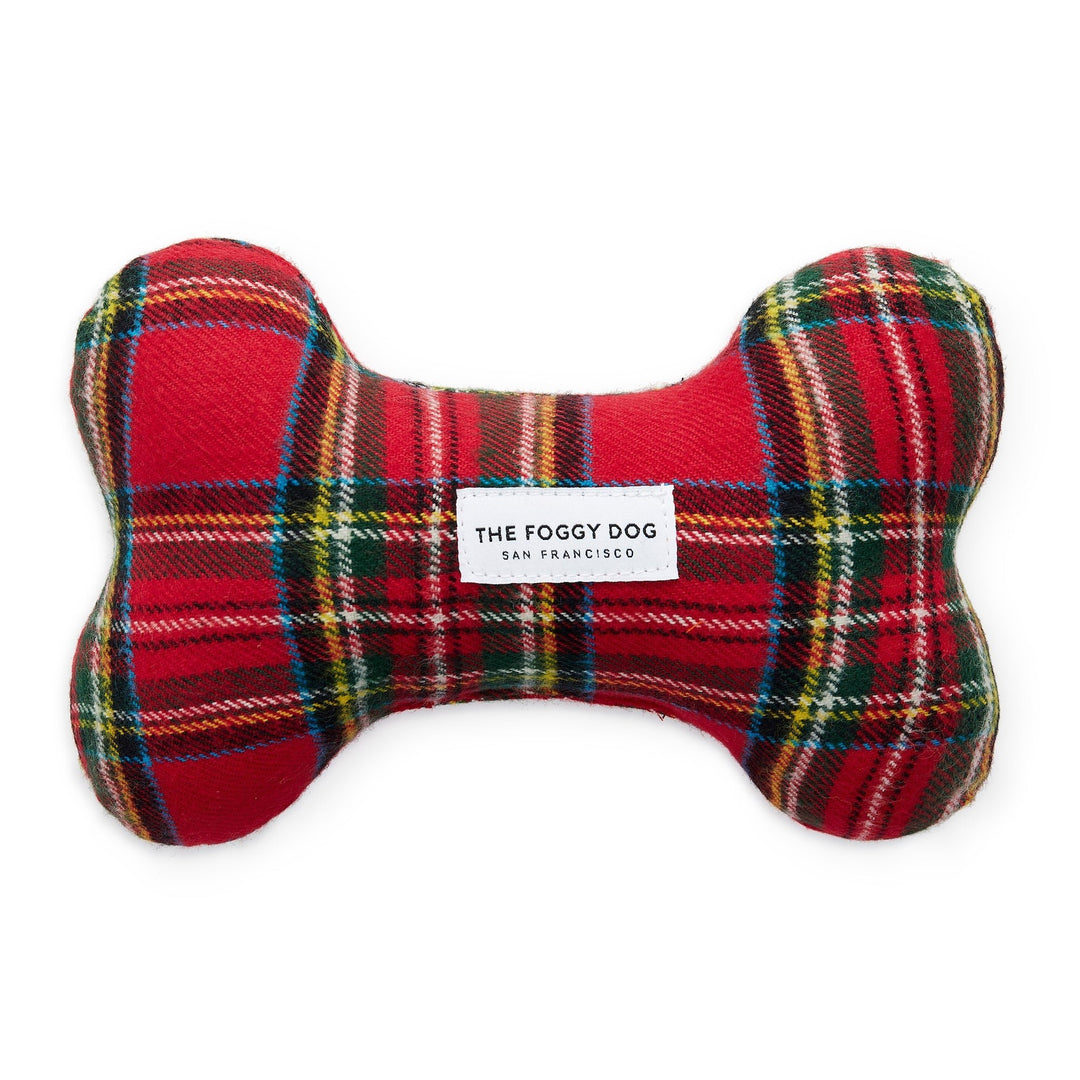 Red tartan plaid flannel bone-shaped dog squeaky toy with a white brand label on white