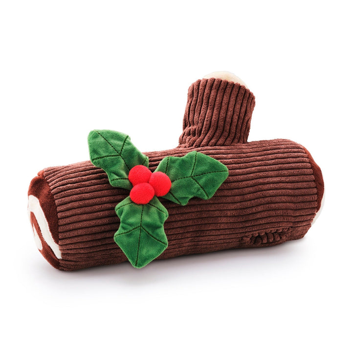 Brown corduroy yule log dog toy with cream swirl ends and green holly with red berries on white