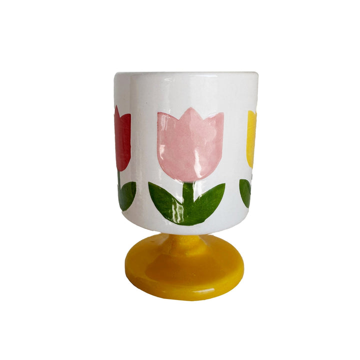 White footed ceramic cup with pink and red tulips on a sunny yellow pedestal base for a spring brunch