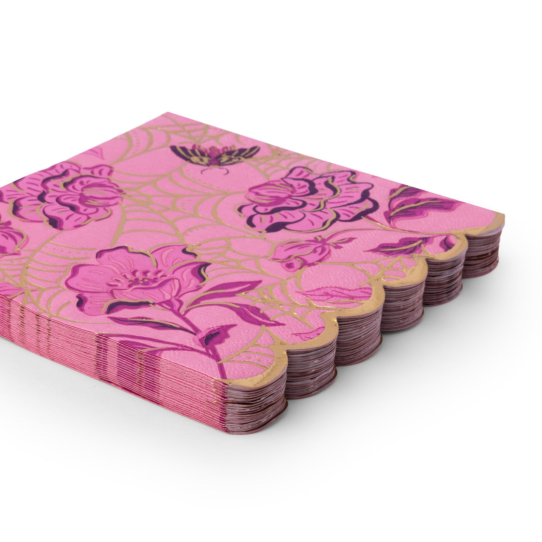Stack of pink scalloped Halloween lunch napkins with a gold spider-web and floral print