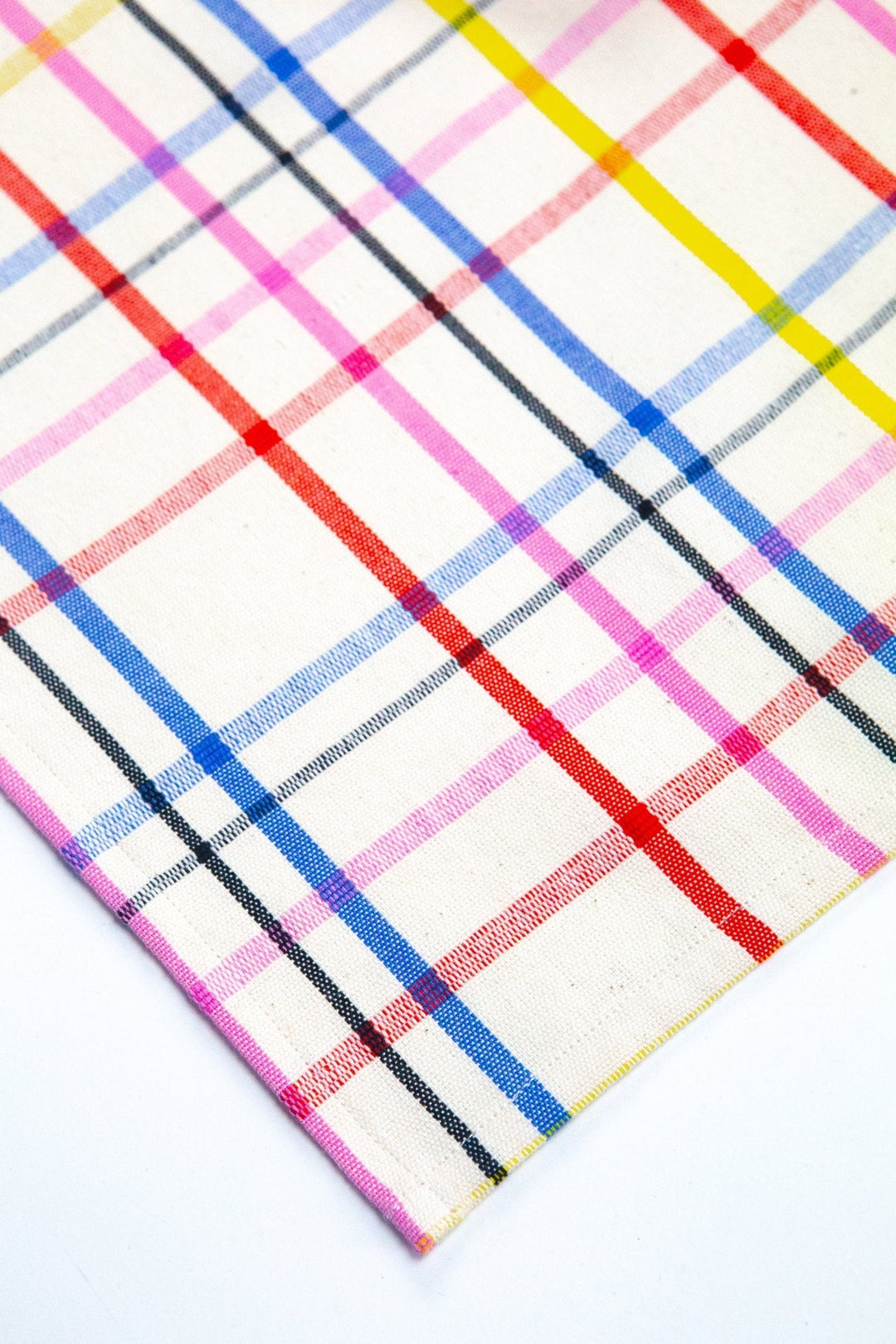 Bright plaid table runner in pink, blue, red, and yellow across a dining table