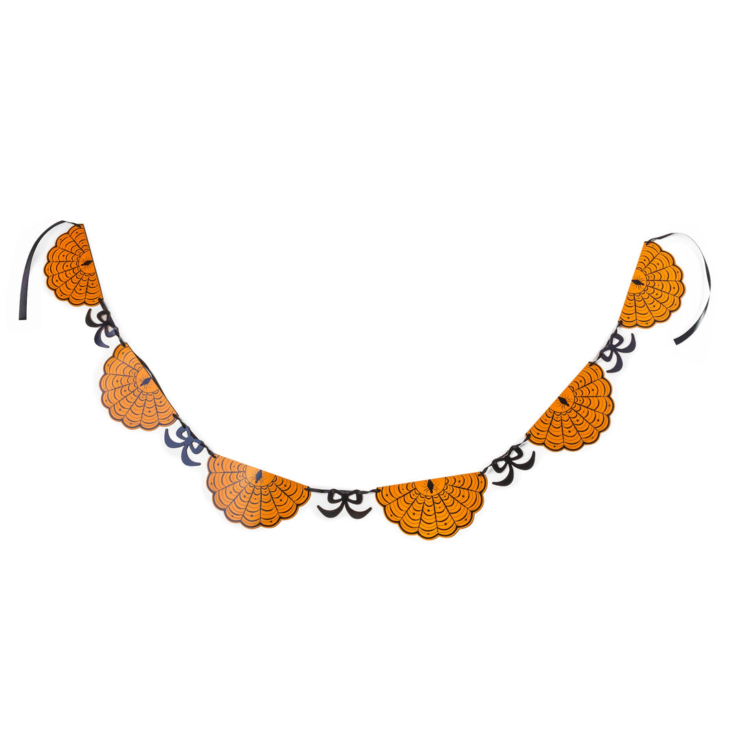 Orange scalloped fan rosettes with black spider-web lines and spiders, linked by black moons and bows, Halloween garland.