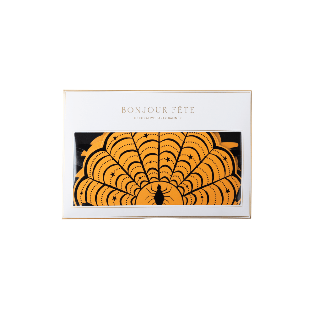 Halloween spider web banner garland in packaging with orange web patterns and black scroll details on a white background.