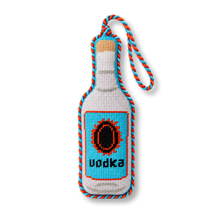 Vodka bottle needlepoint ornament with a blue label, cork top, and blue and red twisted cord, front view