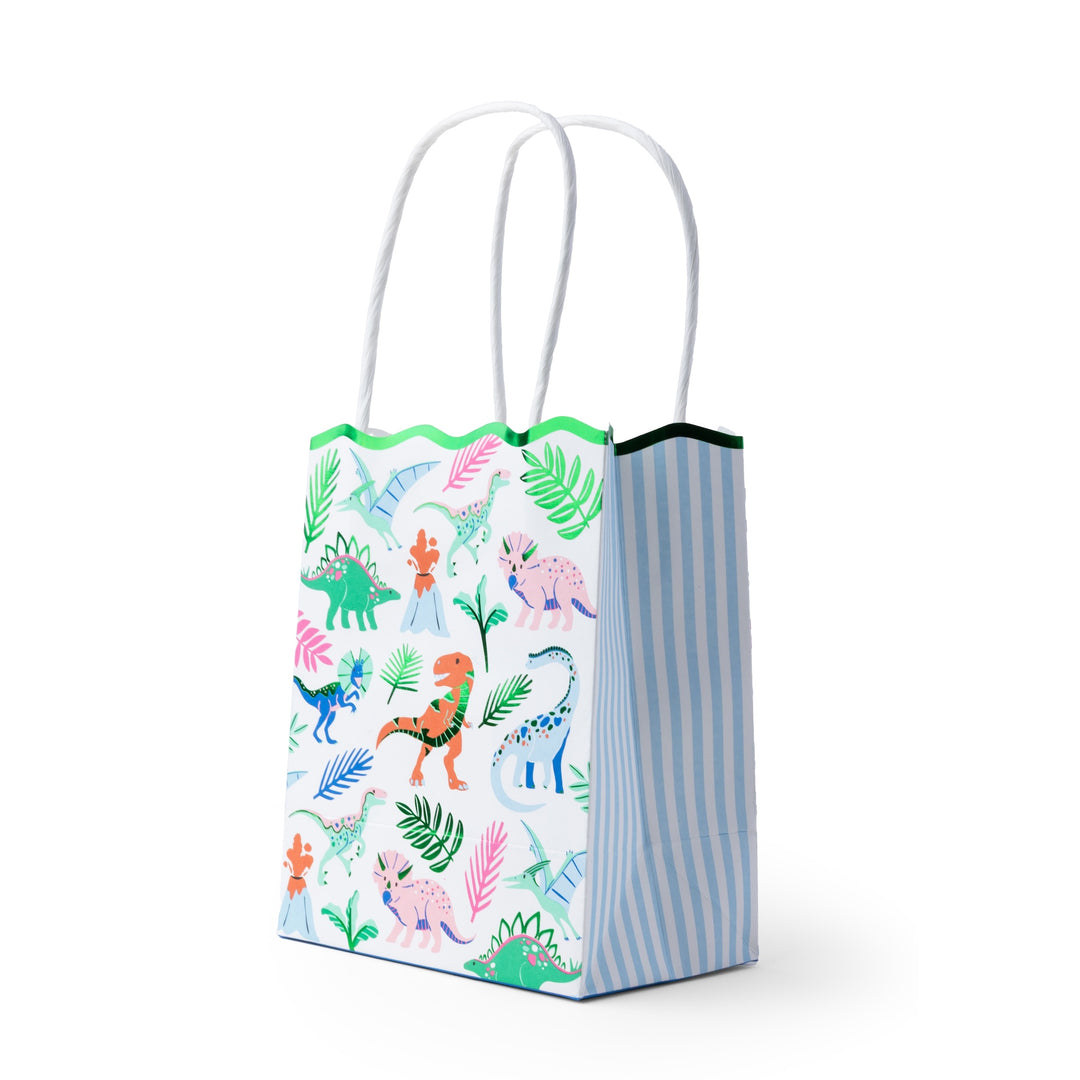 Dinosaur goodie bag with white handles, a colorful dino print, a green scalloped top, and blue striped sides