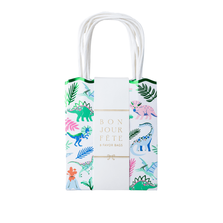 Set of 8 dinosaur favor bags wrapped in a Bonjour Fête band, with green scalloped tops and a colorful dino print