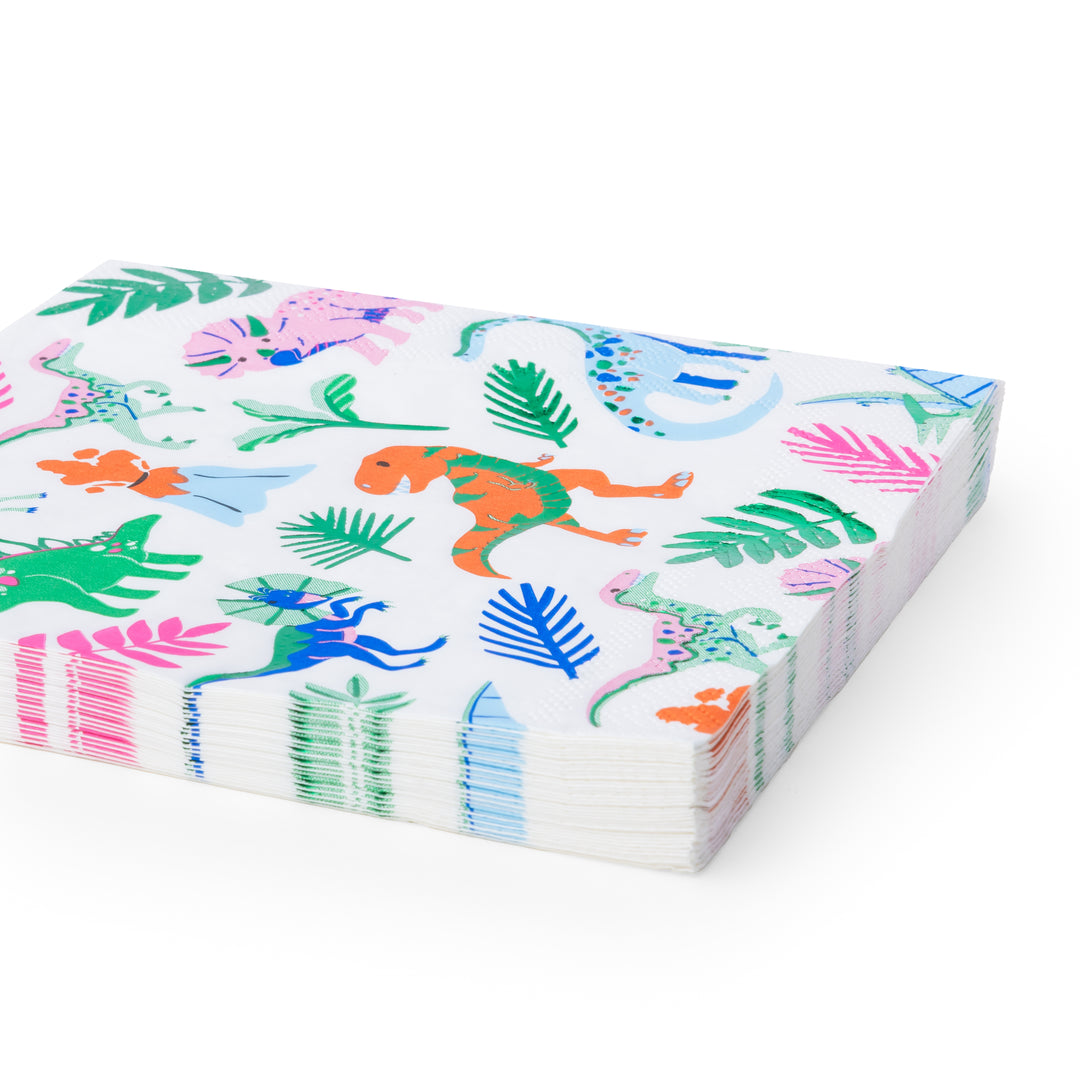 A stack of white paper napkins featuring a colorful dinosaur and jungle print, photographed on a clean white background.