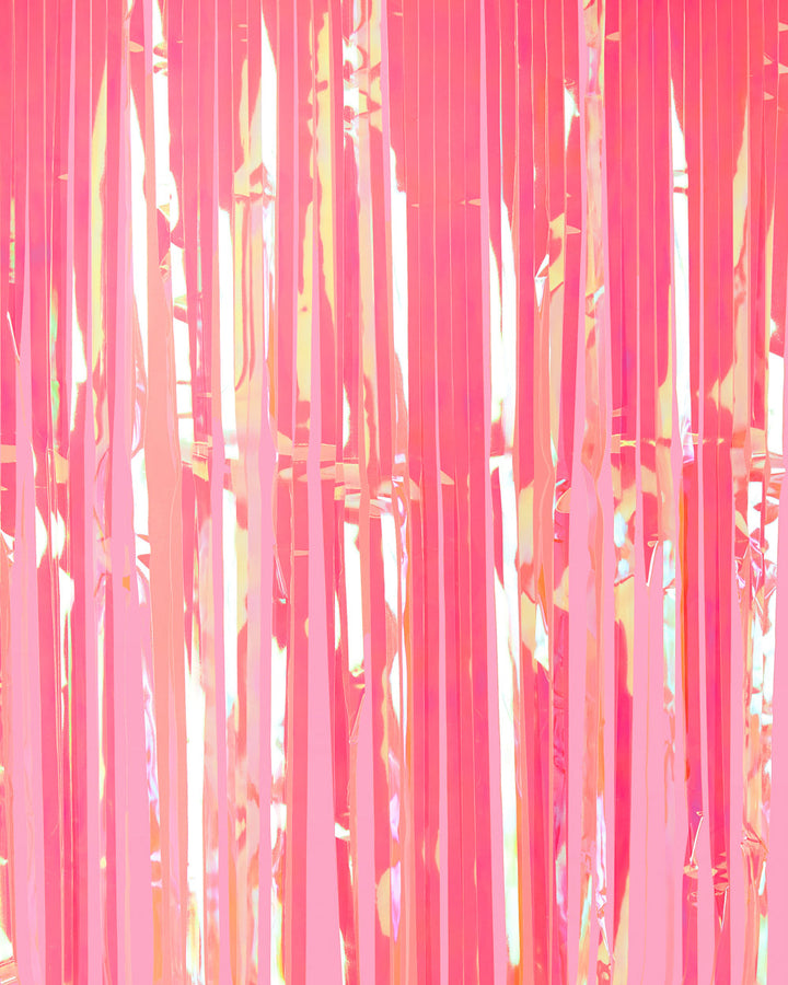 Hot pink iridescent fringe curtain strands shifting toward peach and gold in the light