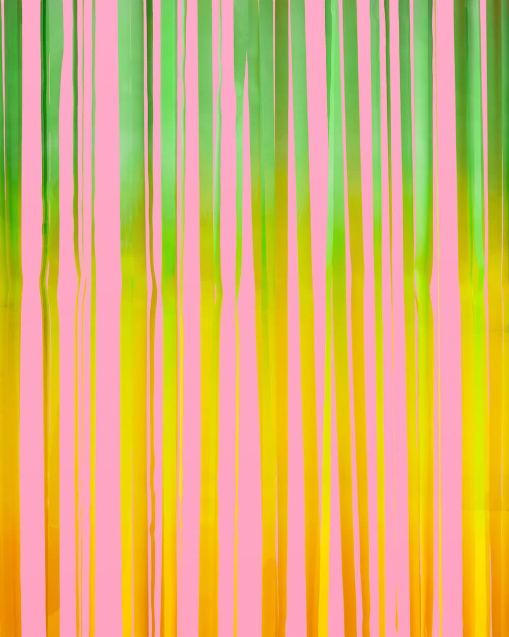 Close-up of pastel green, yellow, and pink fringe strands on a rainbow curtain backdrop