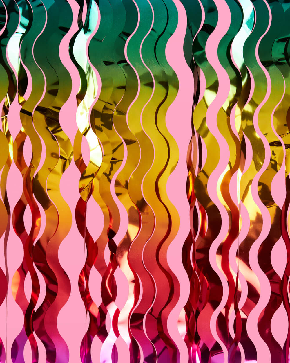 Close-up of red, gold, and green wavy metallic foil strands on a rainbow curtain