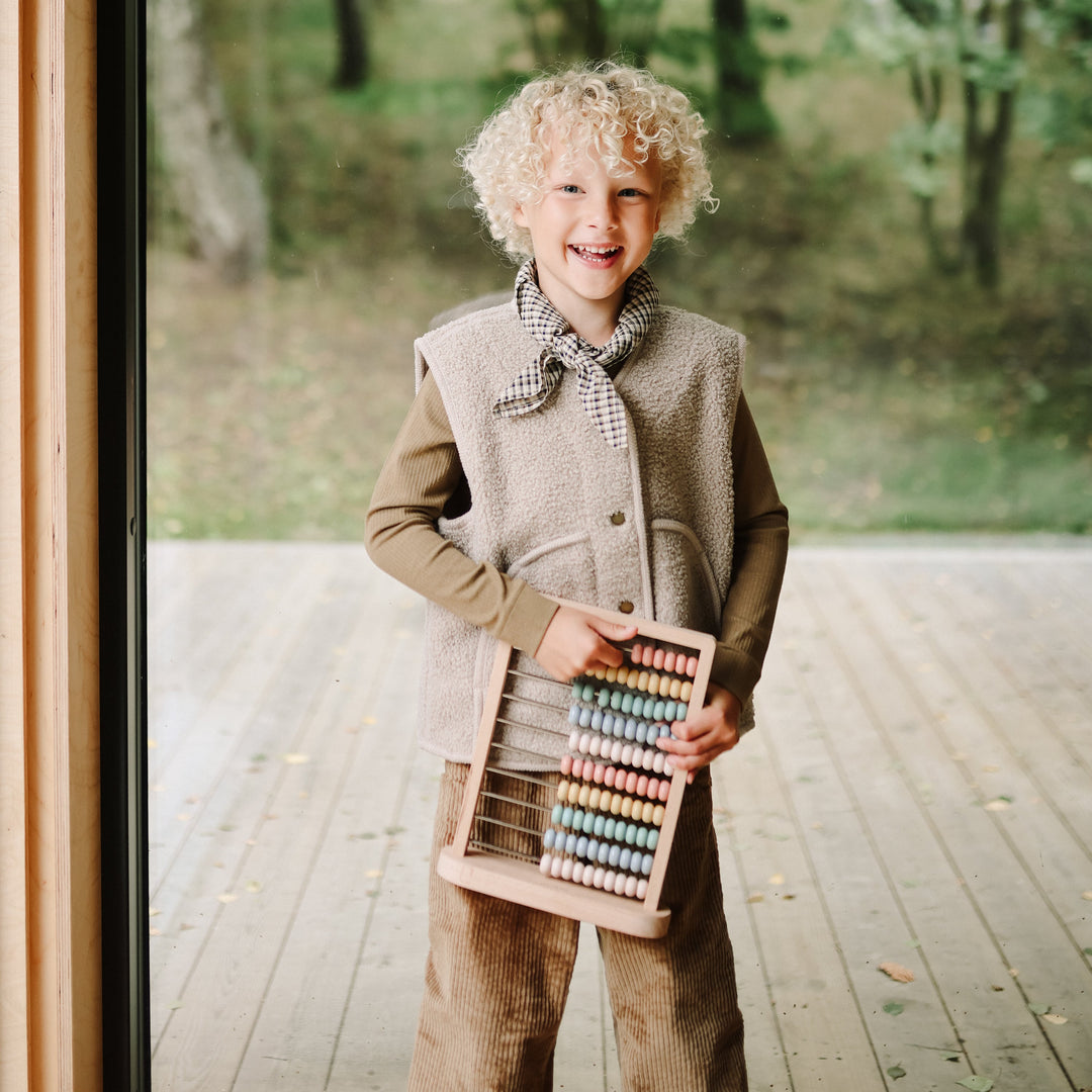 Mushie wooden abacus styled in a nursery