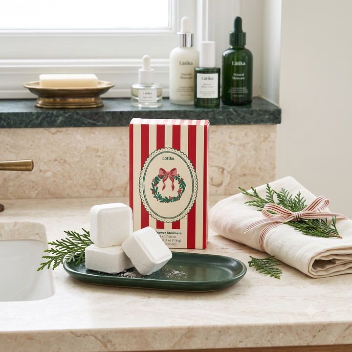 Wreath shower steamer box on a marble vanity with cubes on a green tray and a ribboned towel for holiday spa time