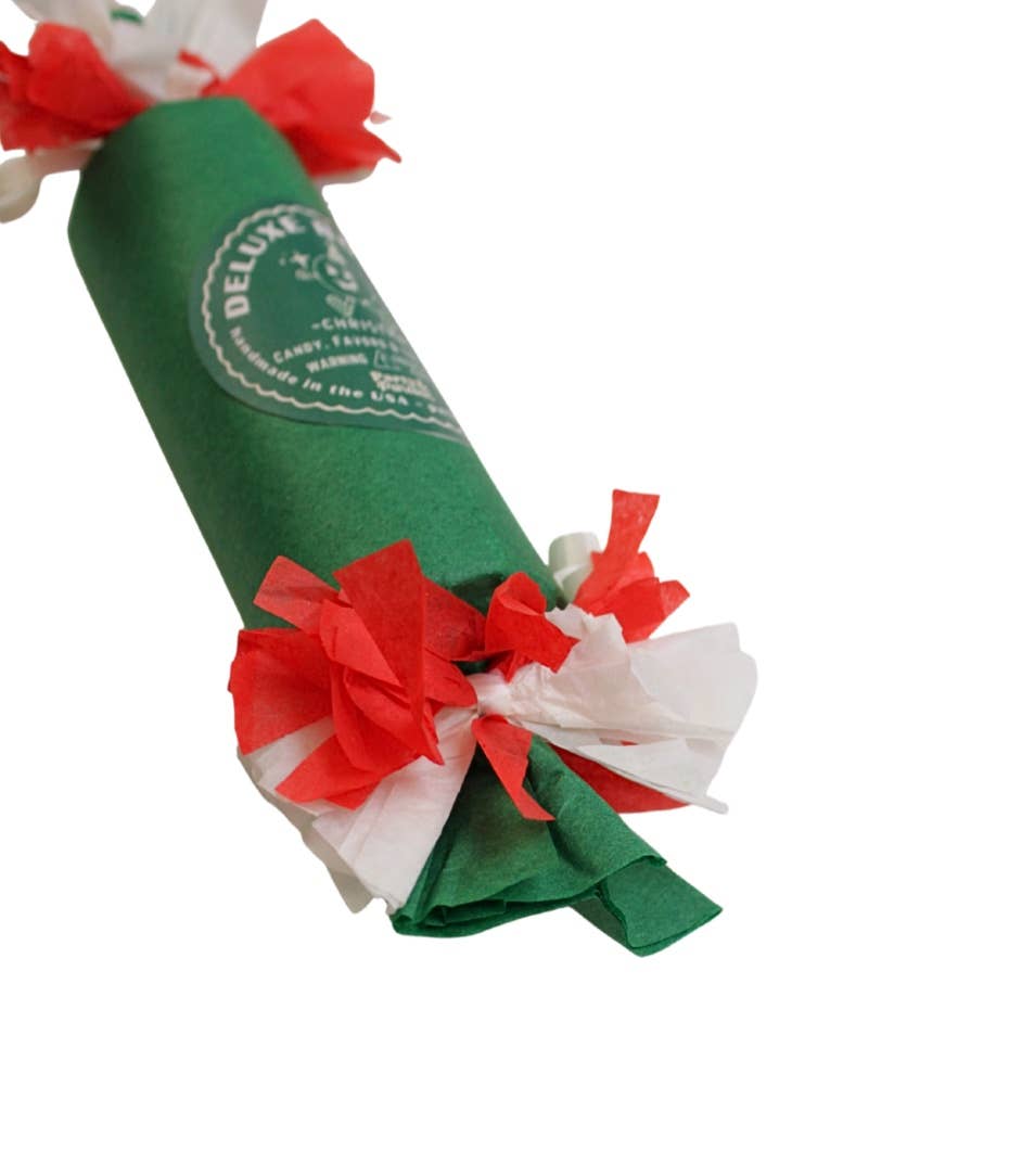 Angled close-up of the green bon bon's printed seal and red and white tissue fringe, a festive holiday table favor