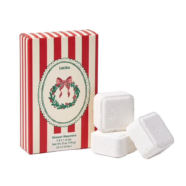 Wreath box beside three stacked white steamer cubes on cream, a simple Christmas self-care gift