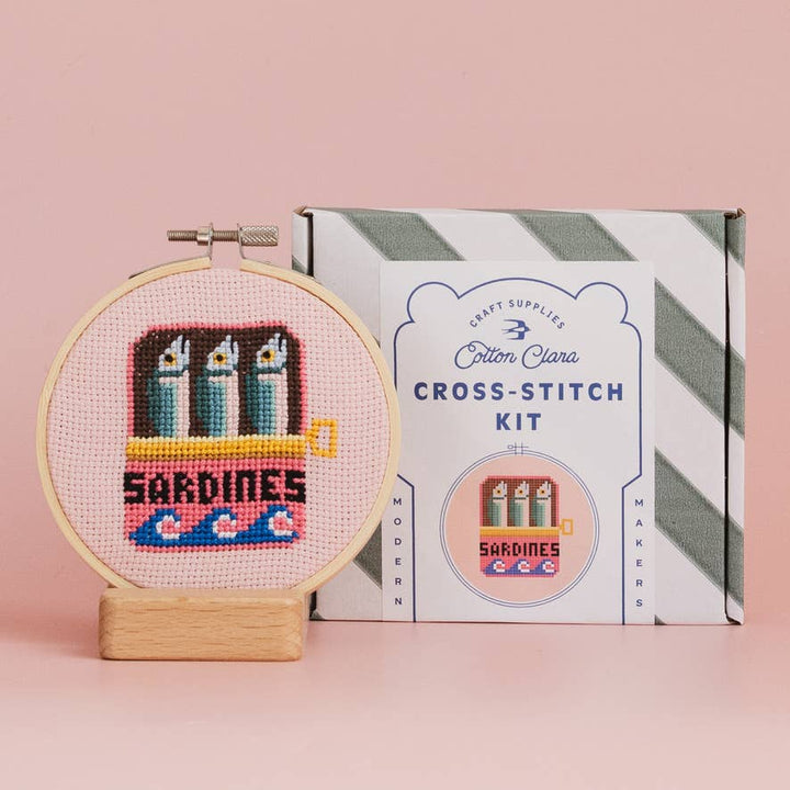 Sardines cross stitch hoop beside Cotton Clara striped kit box for craft night gifting