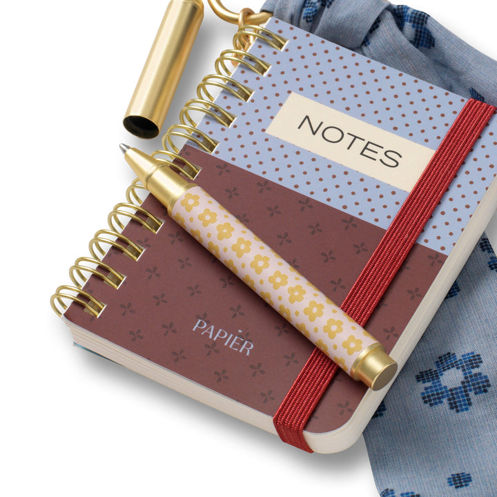 Close up of the mini spiral notebook charm with floral pen and elastic band, on the go notes for busy girls
