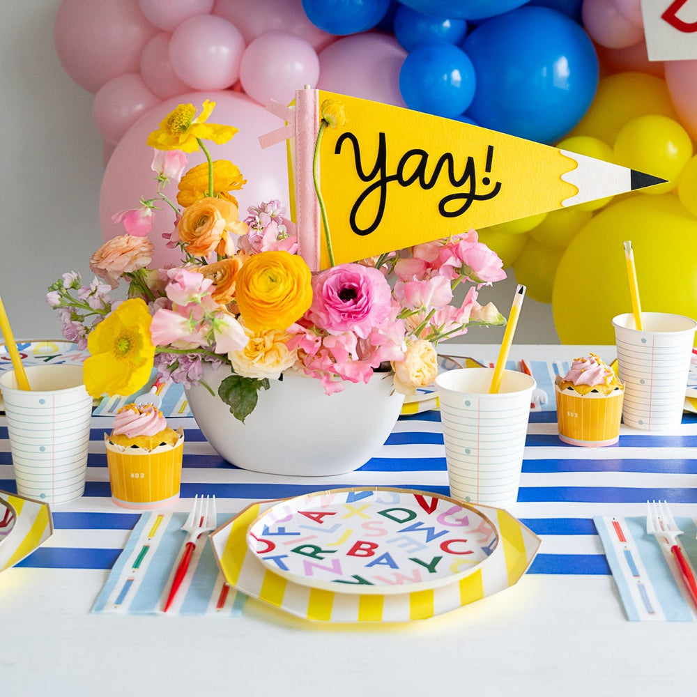 Back to school party table with balloon garland, pencil pennant, alphabet plates, and pencil stripe napkins