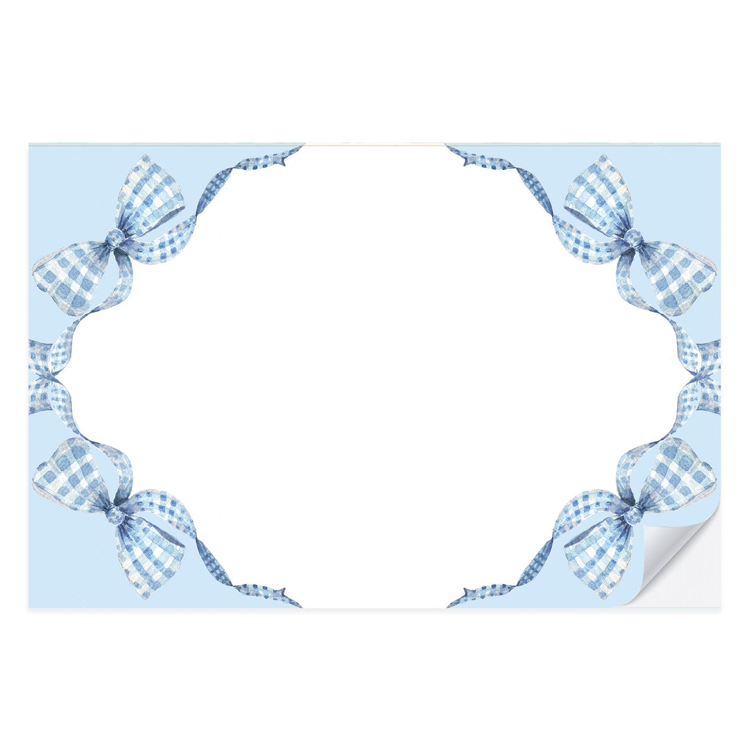 Blue gingham paper placemat with a painted bow at the center, from a tear-off pad of 25