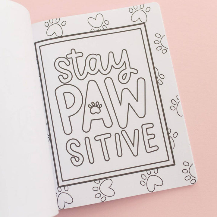 Stay pawsitive hand-lettered coloring page framed by paw prints and hearts