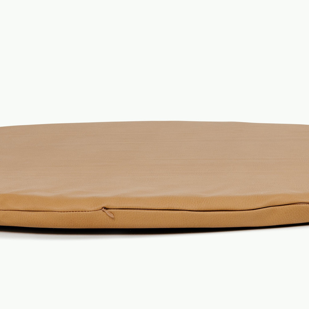 Close-up of the edge on the round camel vegan leather padded play mat
