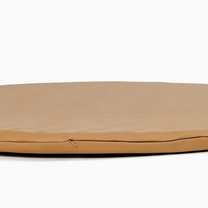 Close-up of the edge on the round camel vegan leather padded play mat