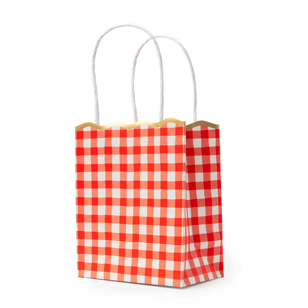 Stack of cherry red gingham favor bags showing the checked pattern and scalloped edge
