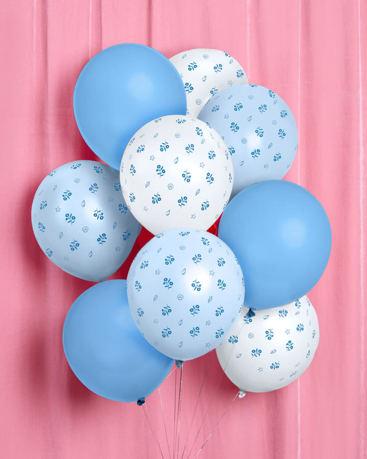 Blue and white coastal latex balloons styled on a sandy beach for a seaside party