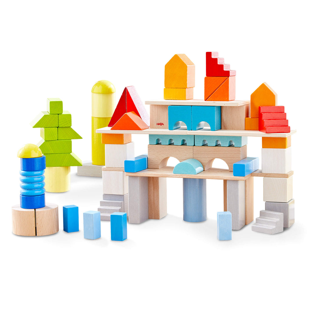 Colored wooden building blocks built into a town with red stairs, yellow and orange roofs, and blue columns on white