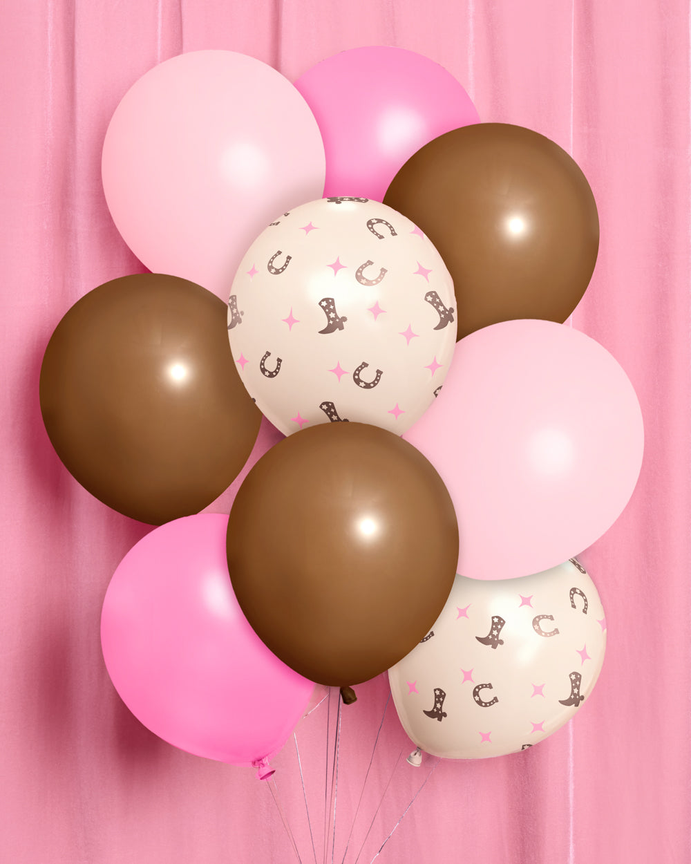 Bunch of cowgirl latex balloons in pink and brown with cowboy boot and horseshoe prints