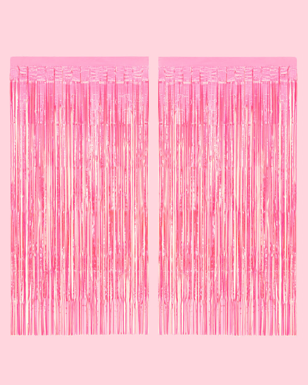 Two hot pink iridescent fringe curtain panels hung side by side on a pale pink wall