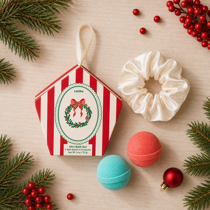 Flat lay of wreath box, ivory scrunchie, aqua and coral bath bombs with berries for a holiday spa night
