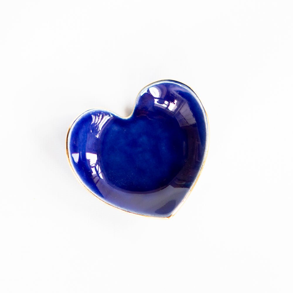 Cobalt blue heart ring dish with a glossy glaze and gold rim, top view