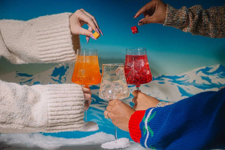 Spritz mixer cube dropping into a glass of prosecco