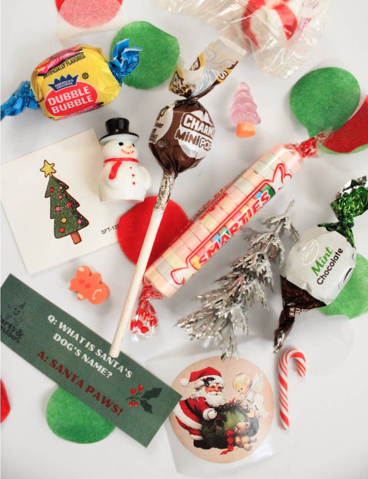 Flat lay of bon bon surprises: retro candies, a candy cane, a mini snowman, a tiny tree, and a Santa trinket for Christmas