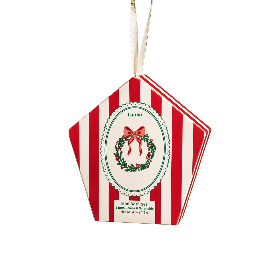 Red striped wreath box hanging on a green Christmas tree with red baubles, a ready-to-hang gift