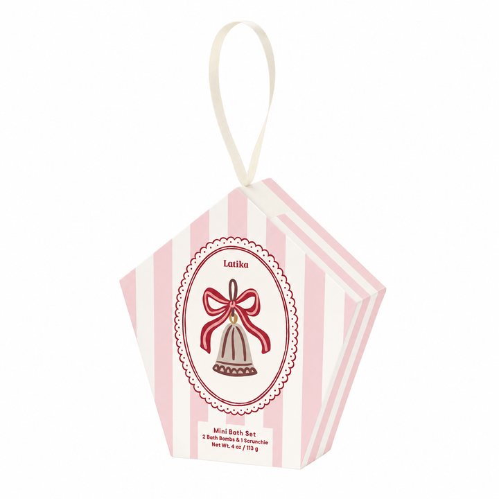 Pink striped pentagon box with looped ribbon and scalloped bell crest on white, a Christmas ornament gift set