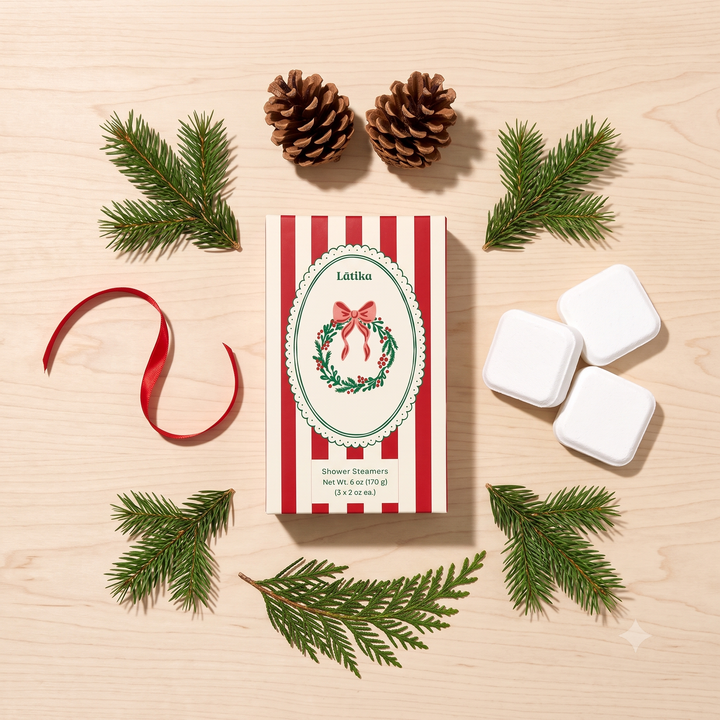 Wreath steamer box with cubes, pinecones and red ribbon arranged on light wood, festive holiday styling