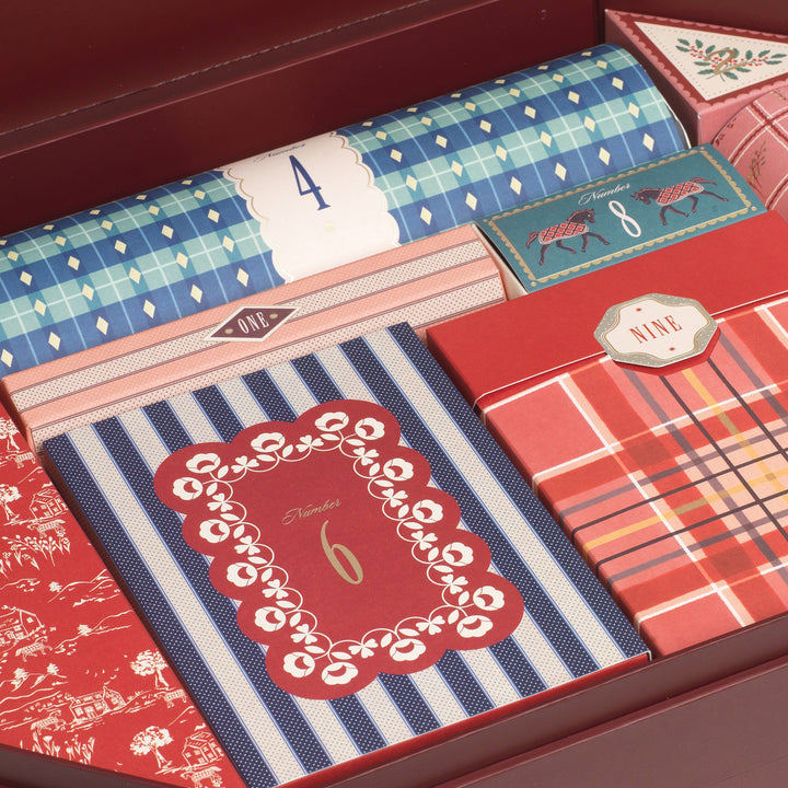 Close up of numbered gift boxes in plaid, stripe, and floral prints inside the stationery advent calendar drawer