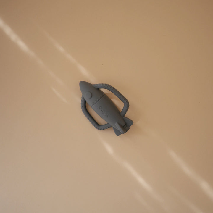 Flat lay of the Mushie silicone rattle teethers with props