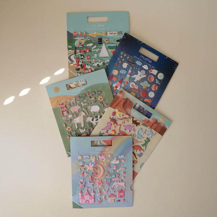 Flat lay of Mushie reusable sticker books across several themes