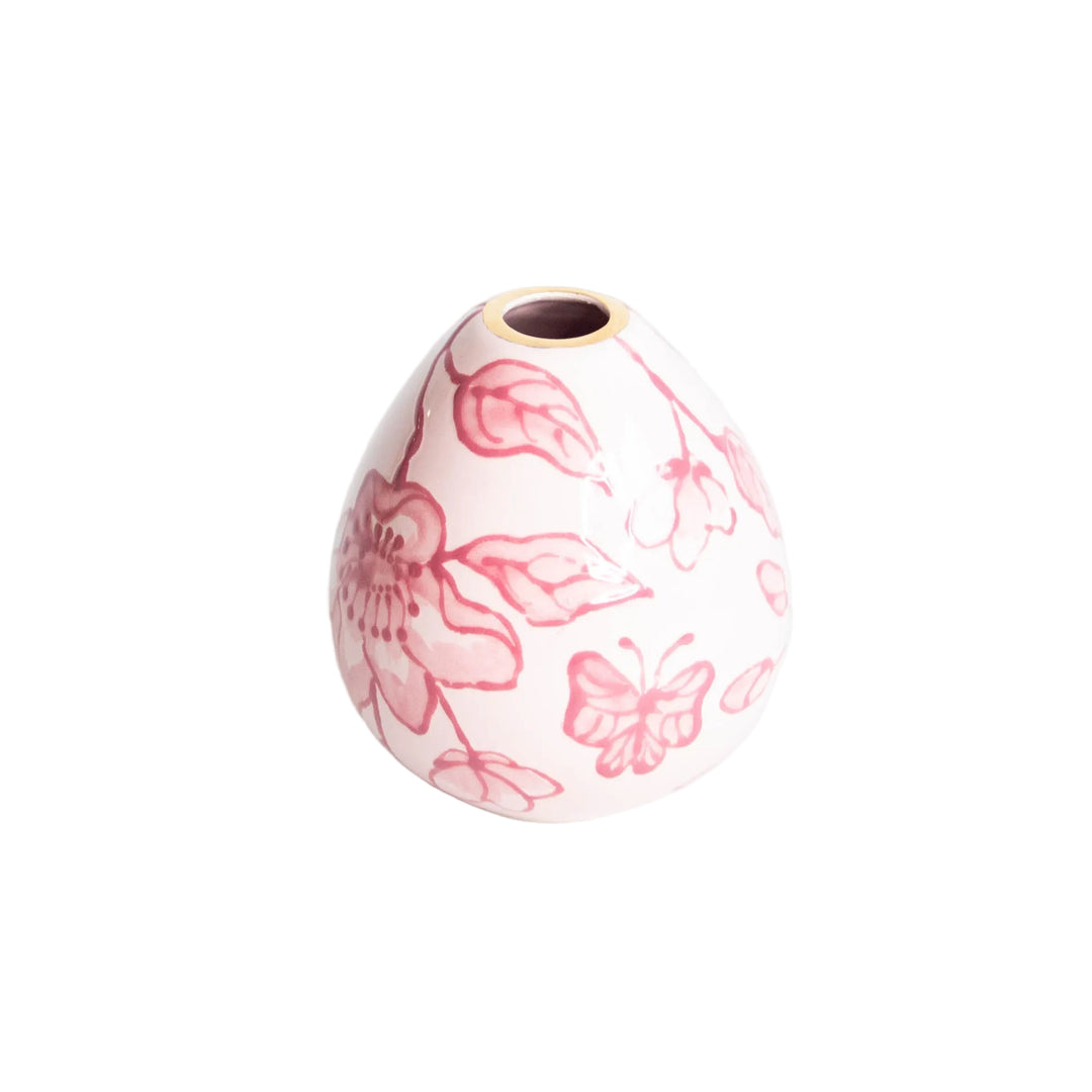 Teardrop shaped pink chinoiserie bud vase painted with blossoms, leaves, and a butterfly on white