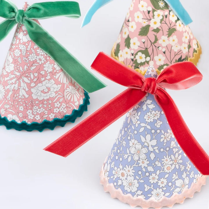 Two decorative fabric hats with ribbons on a white background