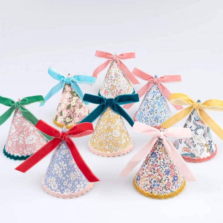 Decorative paper party hats items with colorful ribbons on a light background