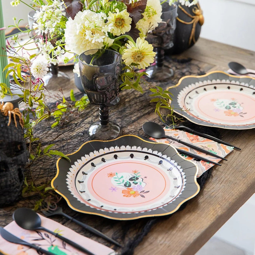 Floral skull party supplies on a tablescape for an elegant Halloween dinner party.
