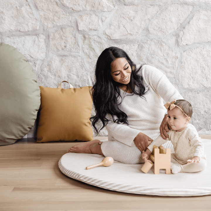 Mother and baby playing with wooden toys on the round cafe stripe padded play mat