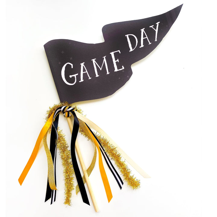 Black Game Day pennant flag with black, gold, and cream ribbons and gold tinsel on a wood dowel