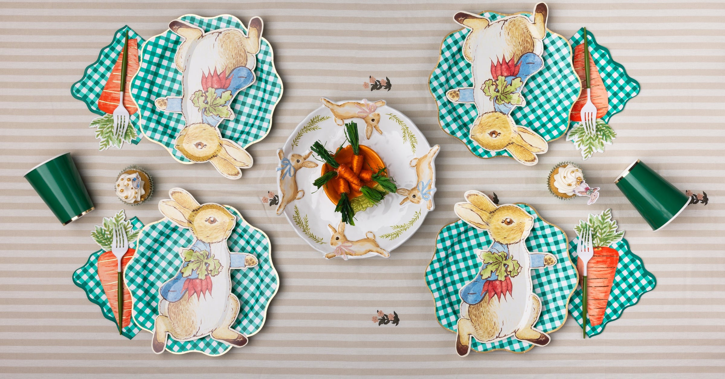 Set of decorative Easter plates with peter rabbit and carrot designs on a striped tablecloth